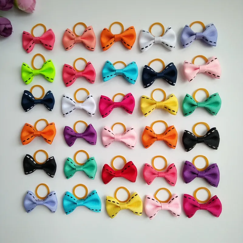 100pcs التي / lot لطيف جرو كلب صغير BOWKNOT الشعر الانحناء مع عصابات المطاط اليدوية إكسسوارات الشعر القوس الحيوانات الأليفة الاستمالة المنتجات