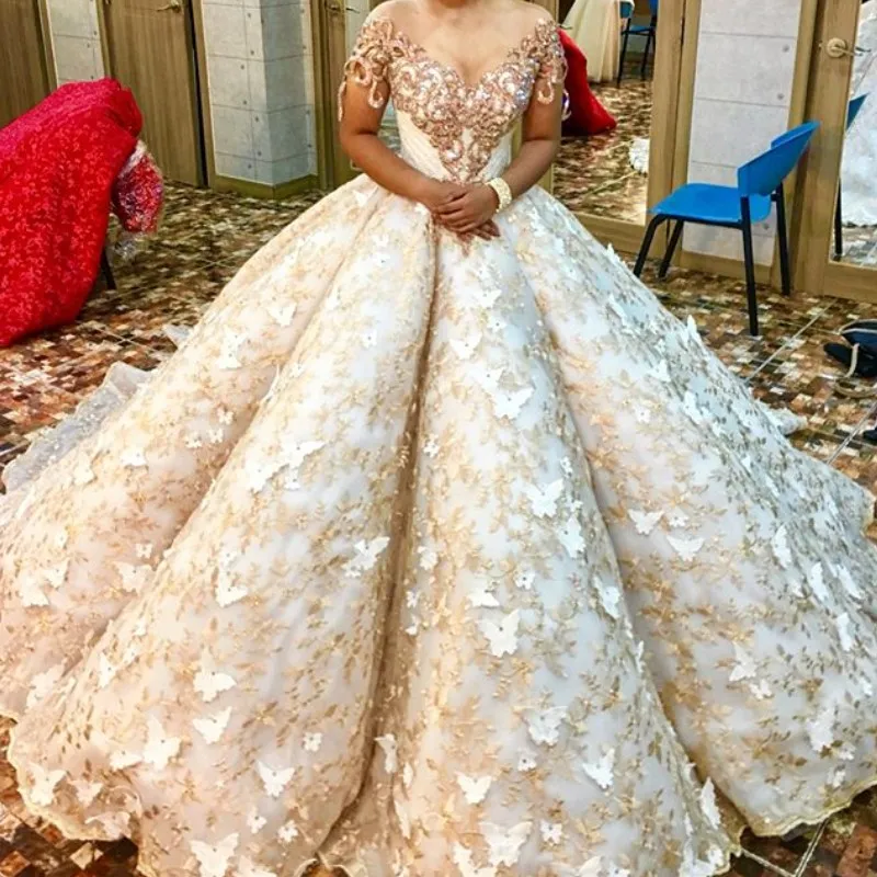Vestido de novia de encaje dorado de lujo Cuello de joya transparente Mangas cortas Apliques de mariposa Vestido de novia saud Glamoroso Cuentas de