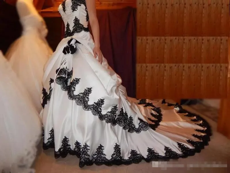 En skräddarsydd linje klänningar vit satin svart applikation tiered kjol svep tåg spetsar upp bröllop brudklänningar pplique