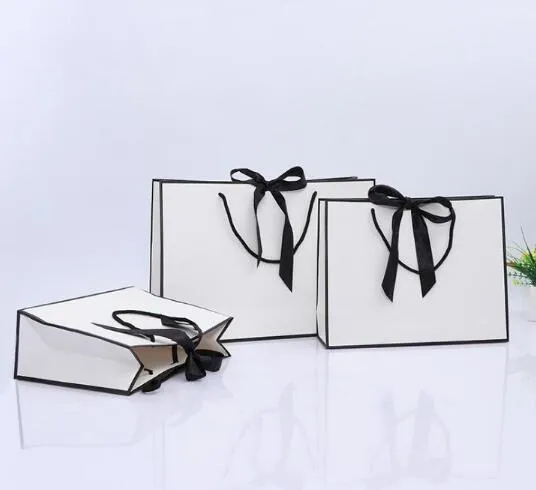100 pièces design créatif bordure noire sac en papier kraft blanc avec poignée faveur de fête de mariage nœud papillon sac cadeau en papier logo personnalisé