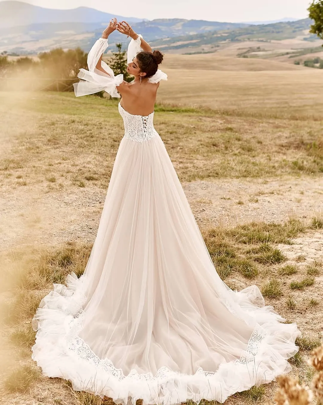 Romantic Lace Beach Wedding dress with Sweetheart Neckline, Long Sleeves, and Tulle Sweep Train - Bohemian Bridal Gown with Ruffled Details