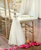 Hermosa muestra de marcos para sillas blancas para decoraciones de boda, flores hechas a mano, cinta para silla, aniversario, gasa, elegante fiesta, banquete A3825417