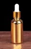 ゴールドアルミキャップが付いている金のガラスの滴ボトル50ml 100mlの香水エッセンシャルオイル電気メッキのガラス瓶