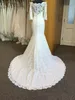 Robe de mariée en dentelle design 2020, ajustée et évasée, manches 3/4, épaules dénudées, dentelle transparente, décolleté avant et arrière