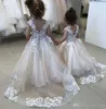 Abiti da ragazza di fiore a buon mercato in pizzo per i bottoni da sposa Indietro Abiti da cerimonia per bambini Tulle Sweep Train Appliqued Vestito da comunione per bambini