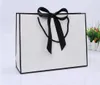 100 pièces design créatif bordure noire sac en papier kraft blanc avec poignée faveur de fête de mariage nœud papillon sac cadeau en papier logo personnalisé