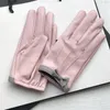 Kurze Damen-Schaffellhandschuhe aus echtem Leder. Rosafarbener Motorradhandschuh im Schleifendesign