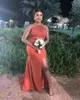 Orangefarbenes Brautjungfernkleid mit seitlichem Schlitz und bodenlangem Meerjungfrau-Abschlussball-Abendkleid mit Falten. Kleid für die Trauzeugin