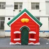 冬のクリスマスの装飾のための屋外のクリスマスの膨脹可能なテント6mの空気吹きの赤い家巨大なクリスマスの村のコテージ