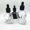 Bouteille d'huile essentielle cosmétique en verre en forme de crâne vide de 30 ml 60 ml avec capuchon noir à l'épreuve des enfants bouteille d'huile de teinture de crâne noir mat en gros