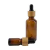 Alta qualità 5ml 10ml 15ml 20ml 30ml 50ml 100ml Bottiglia di siero con contagocce di olio essenziale di vetro ambrato con coperchio in bambù Boston Round HairOil Glass Bottle Fornitore