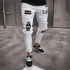 Pantalones rasgados ajustados elásticos de gama alta de estilo hip-hop para hombres de estilo europeo y americano nuevos jeans ajustados con insignia para hombres