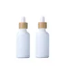 空白の白い磁器の滴ボトル10ml 15ml 20ml 30ml竹のふたが付いているエッセンシャルオイルの化粧品のための100ml