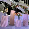 イベントパーティー用品紙の折りたたみシリンダー台座陳列ラックアートピラーのホールダーのためのディザの結婚式の休日デザートケーキのテーブルスタンドの列