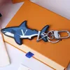 Cartoon Keychains Luxury Designer Fashion Keychain Sliver Keys Buckle äkta läder Blue Shark Pendant Letter Mens Womens väskor O229Y