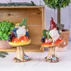 Dekorativa blommor kransar ansiktslös elf gnomes höja hand välkommen skylt trädgård dekoration utomhus sitter på svamp gräsmatta staty dekor