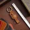 Nyckelringar Bilknapp hängen kedja hängande spänne high-end handrem-knapp cowhide-buttonchain hängsmycke män kvinnor personlighet kreativ
