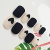 Falska naglar 24pcs falska nageltips för kvinnor frostat matt med lim naken svart kärlekshjärta tryck design Tryck på nageln