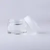 白い帽子の空のクリーム色のコンテナーを詰める詰め替え保管瓶を詰めるガラス化粧品瓶20g 30g 50g