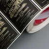 Rotolo di etichette adesive per vino in lamina d'oro goffrato con texture nera personalizzata. Adesivi per bevande impermeabili