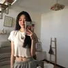T-shirt das mulheres 2022 Senso de projeto do verão Nicho Slim bandagem manga curta sul coreana cortada temperamento top moda