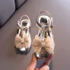 Sandaler 2022 Sommar Barnskor Tjejer Crystal Bowtie Princess T Strap Sandal Cover Toe Flats Gold Pink Dance Dress