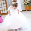 ハーフスリーブの結婚式用の上品なレースフラワーガールドレスアップリケされた小さな女の子のページェントドレスチュールスイープトレーニング