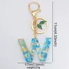 Nuova moda inglese lettera portachiavi in resina piccoli fiori blu con ciondolo a forma di ciondolo in lamina d'oro per donna