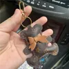 Nyckelringar Cow Nyckelkedjor Tillbehör Brun Flower Teddy Bear Pu Leather Car Keychains Rings smycken Kvinnor MÄNNING ANMÄRKNINGAR CHARMS PENDANT GENTER