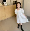 2021 Ano Novo para Criança Meninas Princesa Vestido Bonito Pescoço Quadrado Buff Manga Sólida Cor Doce Sweet Swing Swing Branco Vestidos Q0716