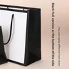 Imballaggio del sacchetto dell'involucro regalo Stampa LOGO personalizzata Bordo nero Maniglia per borsa Carta per la spesa Presente libri di vestiti