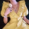 Dabuwawa exklusiv söt gul ruffle v-hals klänning kvinnor sash puff ärm elegant pläterad a-line klänning damer do1bdr005 210520