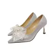 Il nuovo tacco alto dell'arco della perla di modo calza le scarpe da sposa a punta bianche di stile leggiadramente