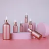 Bouteilles de pipette de réactif en verre avec des bouchons d'or de compte-gouttes contenant de cosmétiques rechargeables d'huile essentielle rose