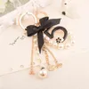 Numer 5 Camellia Torba Wisiorek Dla Kobiety Luksusowa Biżuteria Łuk Car Keyring Bowknot Camellia Pearl Breloki Torba Dekoracja AA220318