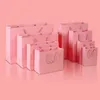 ピンクのコーティングペーパーショッピングギフトラップパッケージングバッグクリスマスウェディング服フェスティバルショッピングバッグ
