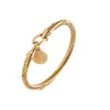 Bracciale rigido in acciaio al titanio Cavo in filo color oro Bracciale rigido con ciondolo a forma di croce di Gesù con chiusura a gancio per regali di gioielli da sposa da donna