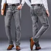 Мужчины растягивают регулярные джинсы. Деловые повседневные классические стиль модные джинсовые брюки мужчины черно -голубые серые брюки