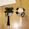 Keychains Luxury Black Camellia Genuine Leather Flower Keychain Letter Umbrella Pendant Car Key Chain Ring For BagKeychains Forb22