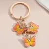 Favor de fiesta nuevo colorido esmalte mariposa llavero insectos llave clave mujer bolso accesorios regalo de joyería