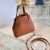 Cowhide skinka håliga tygväskor trapeze hink väska spansk stil nugget handväskor nya fashionabla högkapacitet crossbody kvinnors axelväskor bärbara lo