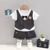 Set di abbigliamento Abiti estivi per neonato Moda coreana O-collo T-shirt scozzesi Top e pantaloncini Abiti firmati per neonati in due pezzi Tute per bambini