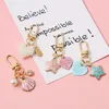 Prix en gros pentagramme coquille Airpods porte-clés pendentif Apple Bluetooth casque ensemble porte-clés sac pendentifs porte-clés accessoires