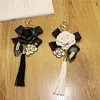 Keychains Luxury Black Camellia Genuine Leather Flower Keychain Letter Umbrella Pendant Car Key Chain Ring For BagKeychains Forb22