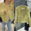 Nella primavera del giallo limone, un piccolo cappotto di tweed grossolano e profumato, una celebrità, in lana con bottoni dorati a doppio petto