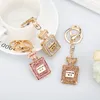 Mode Rhinestones Blinkande Parfymflaska Keychain Vacker läppstift Keychain Key Ring Exquisite Kvinnors Crystal Charm Gift