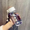 Bouteilles d'eau 500 ml de petite marguerite en plastique transparent bouteilles d'eau bpa bpa créatif gratuit givré avec une tasse de thé de voyage en corde portable