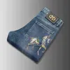 Herr jeans designer vår sommarmärke elastisk koreansk version smal passande fötter gyllene hästtryckt blå byxor qobd