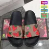 2022 Herrkvinnor tofflor m￤n kvinnor platt tofflor glider blomma svarta blommiga glidmode sandaler med dammv￤ska skor l￥da strandreglage lyx l￤der mans sandal