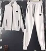 Женщины с двумя частями модные бренды высококачественная классическая печать логотипа Zip Cardigan с разноцветными повседневными брюками 2 сета роскошных дизайнерских спортивных костюмов 0912